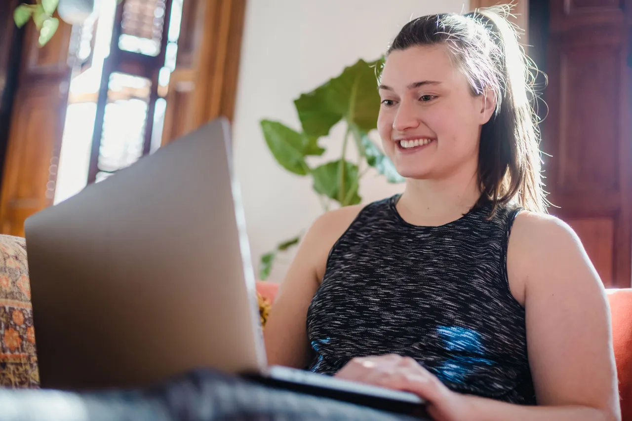 Junge Frau, die Spass hat bei der Arbeit mit der Software, weil sie leicht und verständlich ist.