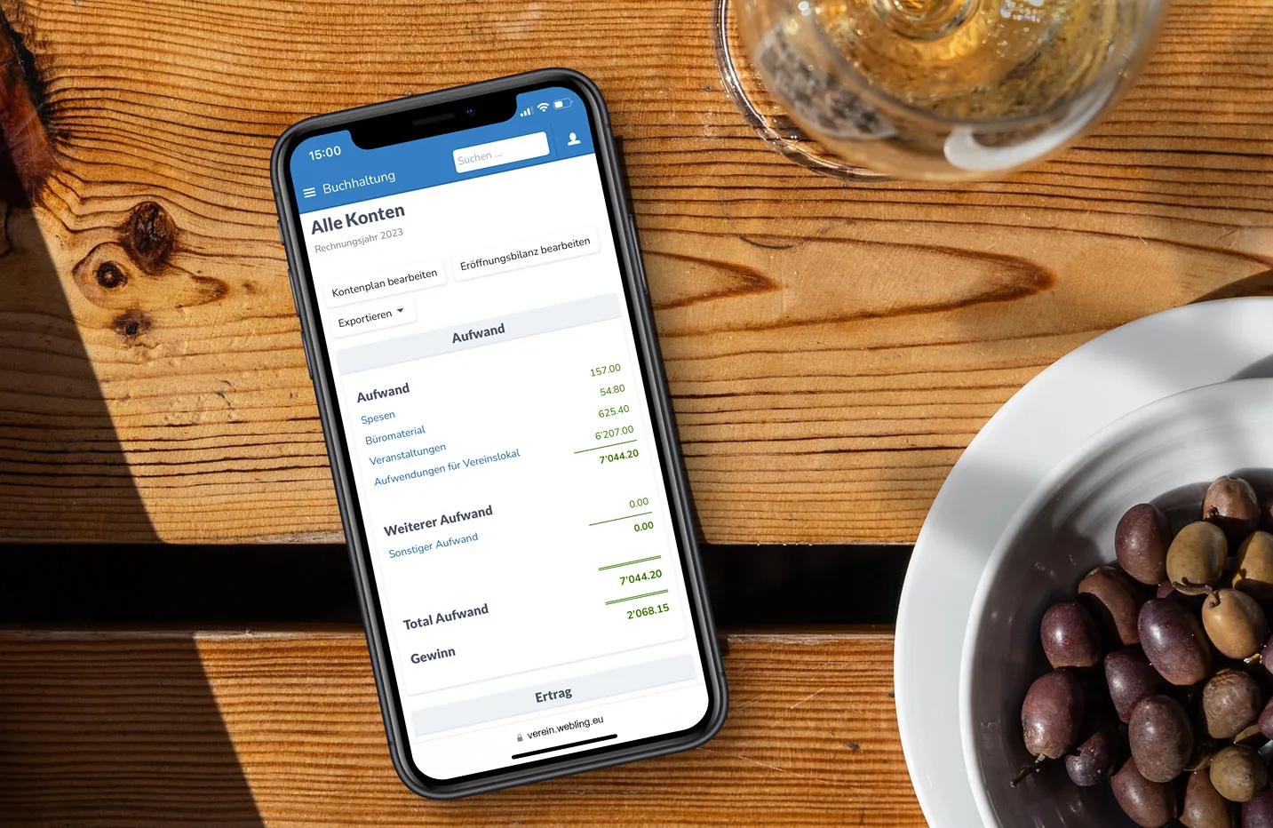 Online-Vereinsbuchhaltung auf einem Smartphone, das auf einem Holztisch liegt